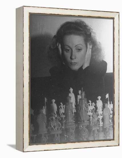 Close Up of Danielle Darrieux Looking at Chess Pieces-David Scherman-Framed Premier Image Canvas