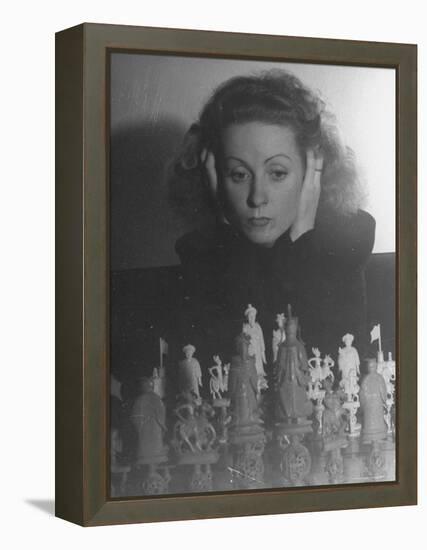 Close Up of Danielle Darrieux Looking at Chess Pieces-David Scherman-Framed Premier Image Canvas