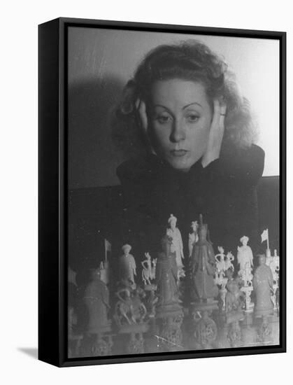 Close Up of Danielle Darrieux Looking at Chess Pieces-David Scherman-Framed Premier Image Canvas