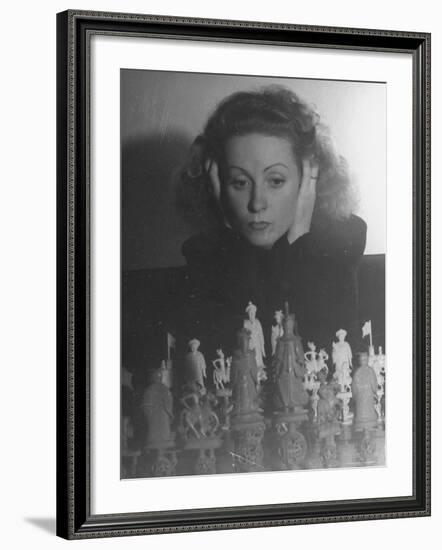 Close Up of Danielle Darrieux Looking at Chess Pieces-David Scherman-Framed Premium Photographic Print