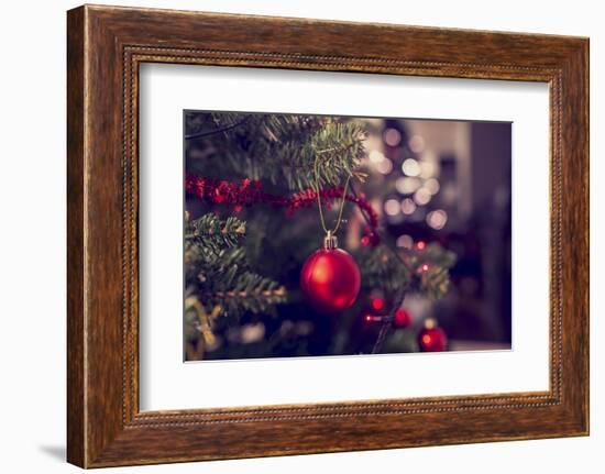 Closeup of Red Bauble Hanging from a Decorated Christmas Tree. Retro Filter Effect.-Gajus-Framed Photographic Print