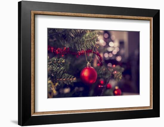 Closeup of Red Bauble Hanging from a Decorated Christmas Tree. Retro Filter Effect.-Gajus-Framed Photographic Print