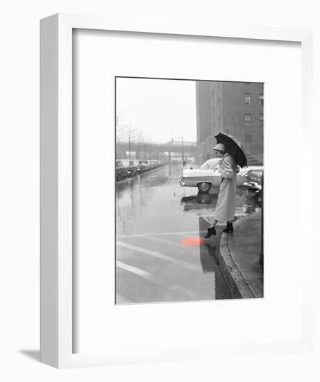 Color Pop,1950s WOMAN IN RAIN COAT HAT BOOTS HOLDING UMBRELLA CROSSING CITY STREET-null-Framed Photographic Print