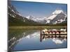 Colorful Canoes Line the Dock at Many Glacier Lodge on Swiftcurrent Lake During Sunrise-Brad Beck-Mounted Photographic Print