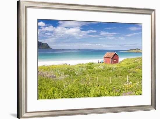 Colorful flowers on green meadows frame the typical rorbu surrounded by turquoise sea, Ramberg, Lof-Roberto Moiola-Framed Photographic Print