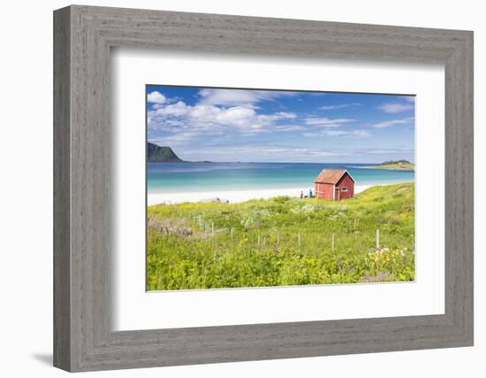 Colorful flowers on green meadows frame the typical rorbu surrounded by turquoise sea, Ramberg, Lof-Roberto Moiola-Framed Photographic Print