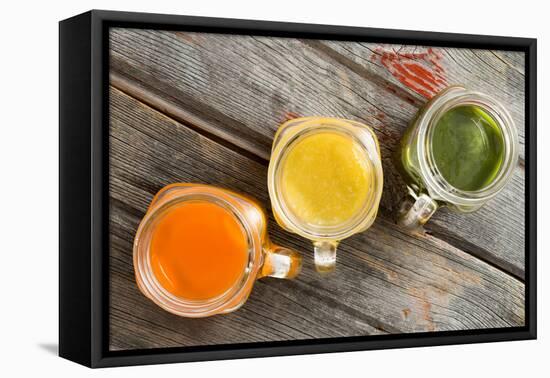 Colorful Trio of Fresh Fruit Juice in Glass Jugs-oocoskun-Framed Premier Image Canvas