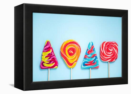 Colorful Vibrant Lollipops, Flat Lay on Blue Background-Marcin Jucha-Framed Premier Image Canvas