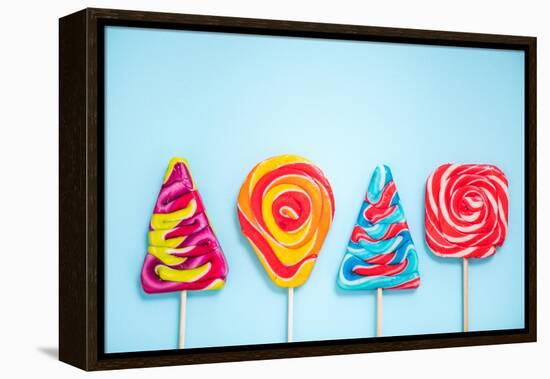 Colorful Vibrant Lollipops, Flat Lay on Blue Background-Marcin Jucha-Framed Premier Image Canvas