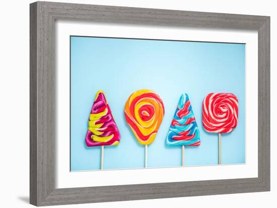 Colorful Vibrant Lollipops, Flat Lay on Blue Background-Marcin Jucha-Framed Photographic Print