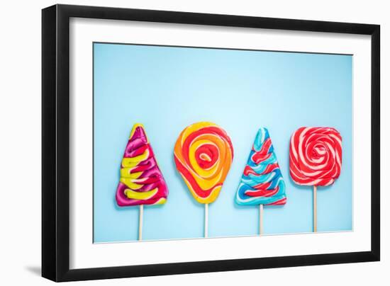 Colorful Vibrant Lollipops, Flat Lay on Blue Background-Marcin Jucha-Framed Photographic Print