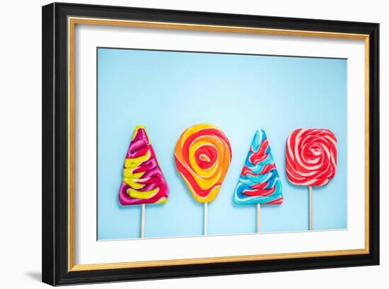 Colorful Vibrant Lollipops, Flat Lay on Blue Background-Marcin Jucha-Framed Photographic Print