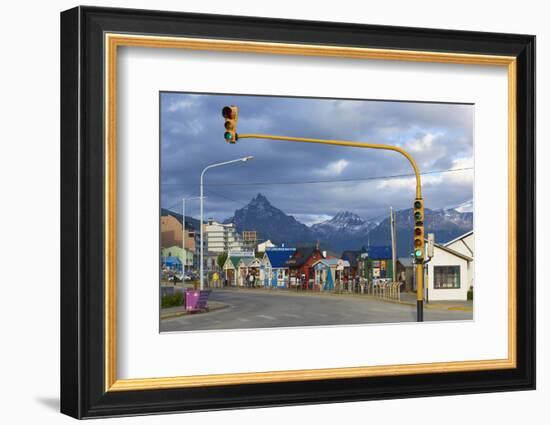 Colourful houses on touristic road framed by traffic lights post with snowy mountain chain beyond, -Fernando Carniel Machado-Framed Photographic Print