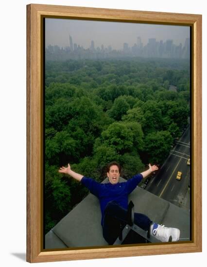 Comedian Jerry Seinfeld Perching Precariously on Roof Ledge Overlooking Central Park-Ted Thai-Framed Premier Image Canvas