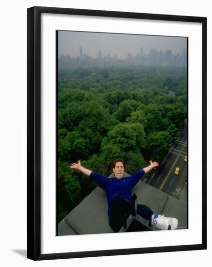 Comedian Jerry Seinfeld Perching Precariously on Roof Ledge Overlooking Central Park-Ted Thai-Framed Premium Photographic Print