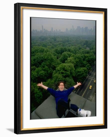 Comedian Jerry Seinfeld Perching Precariously on Roof Ledge Overlooking Central Park-Ted Thai-Framed Premium Photographic Print