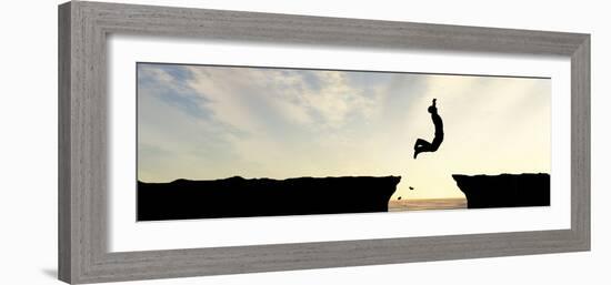 Concept or Conceptual Young Man, Businessman Silhouette Jump Happy from Cliff over Water Gap Sunset-bestdesign36-Framed Photographic Print