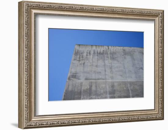 Concrete grey wall with structure and inclusions as a background in front of sky blue cloudless-Axel Killian-Framed Photographic Print