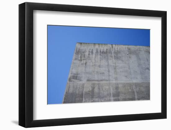 Concrete grey wall with structure and inclusions as a background in front of sky blue cloudless-Axel Killian-Framed Photographic Print