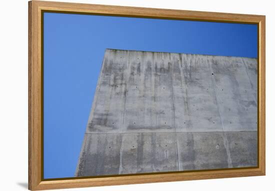 Concrete grey wall with structure and inclusions as a background in front of sky blue cloudless-Axel Killian-Framed Premier Image Canvas