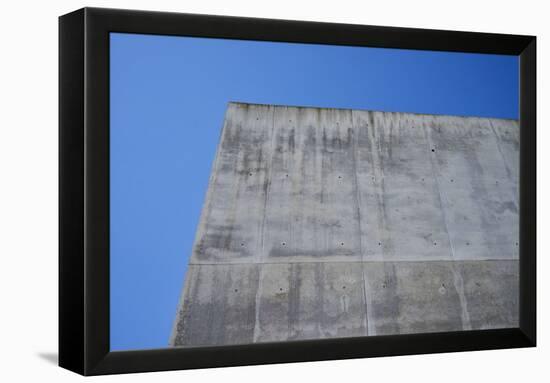 Concrete grey wall with structure and inclusions as a background in front of sky blue cloudless-Axel Killian-Framed Premier Image Canvas