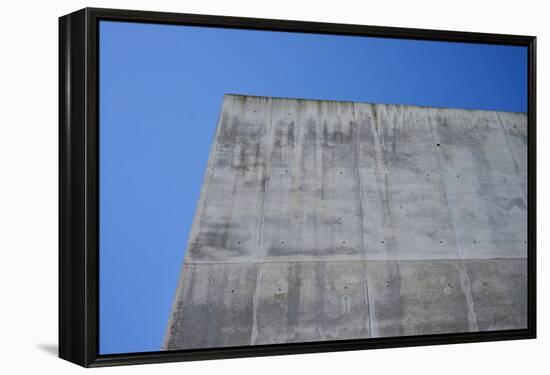 Concrete grey wall with structure and inclusions as a background in front of sky blue cloudless-Axel Killian-Framed Premier Image Canvas