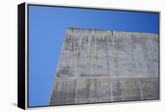 Concrete grey wall with structure and inclusions as a background in front of sky blue cloudless-Axel Killian-Framed Premier Image Canvas