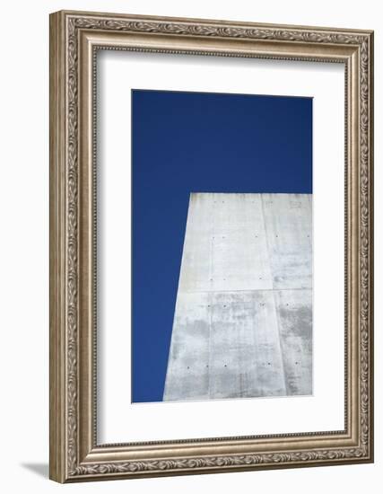 Concrete grey wall with structure and inclusions as a background in front of sky blue cloudless-Axel Killian-Framed Photographic Print