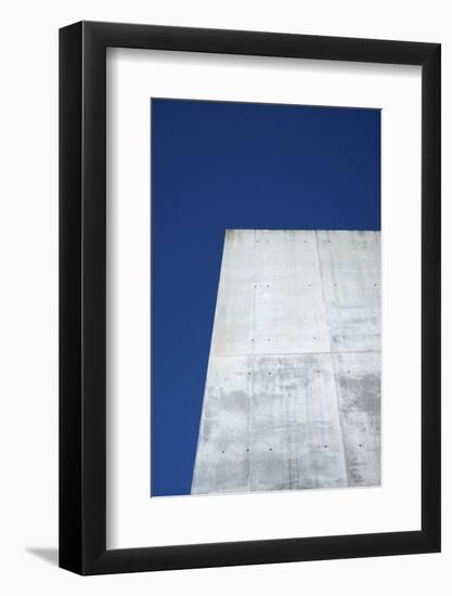 Concrete grey wall with structure and inclusions as a background in front of sky blue cloudless-Axel Killian-Framed Photographic Print