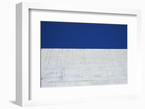 Concrete grey wall with structure and inclusions as a background in front of sky blue cloudless-Axel Killian-Framed Photographic Print