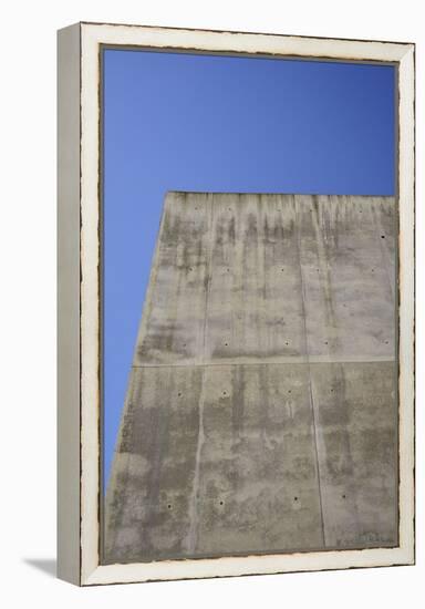 Concrete grey wall with structure and inclusions as a background in front of sky blue cloudless-Axel Killian-Framed Premier Image Canvas