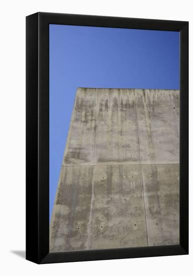 Concrete grey wall with structure and inclusions as a background in front of sky blue cloudless-Axel Killian-Framed Premier Image Canvas