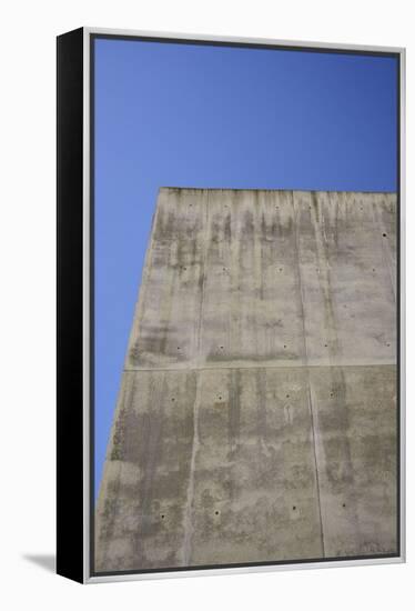 Concrete grey wall with structure and inclusions as a background in front of sky blue cloudless-Axel Killian-Framed Premier Image Canvas