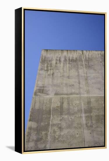 Concrete grey wall with structure and inclusions as a background in front of sky blue cloudless-Axel Killian-Framed Premier Image Canvas