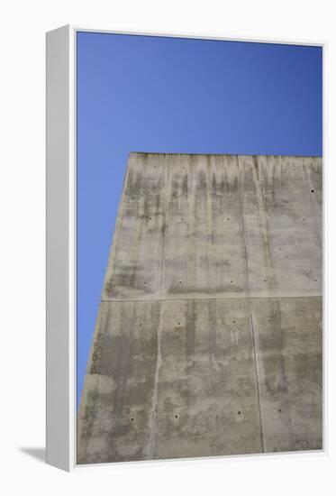 Concrete grey wall with structure and inclusions as a background in front of sky blue cloudless-Axel Killian-Framed Premier Image Canvas