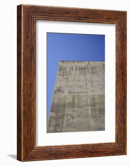 Concrete grey wall with structure and inclusions as a background in front of sky blue cloudless-Axel Killian-Framed Photographic Print