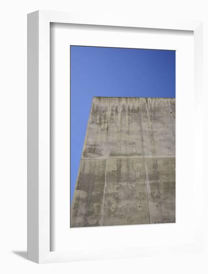 Concrete grey wall with structure and inclusions as a background in front of sky blue cloudless-Axel Killian-Framed Photographic Print