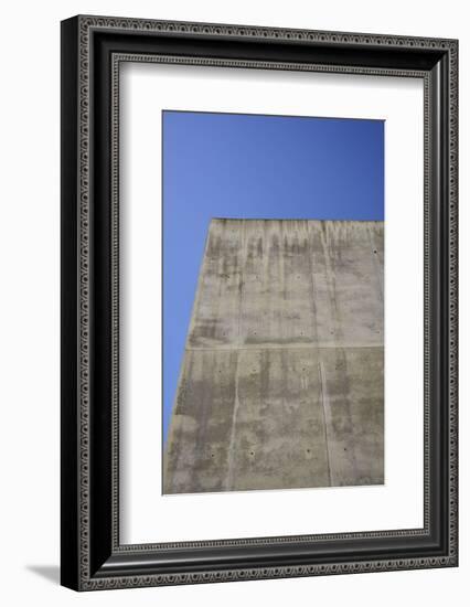 Concrete grey wall with structure and inclusions as a background in front of sky blue cloudless-Axel Killian-Framed Photographic Print