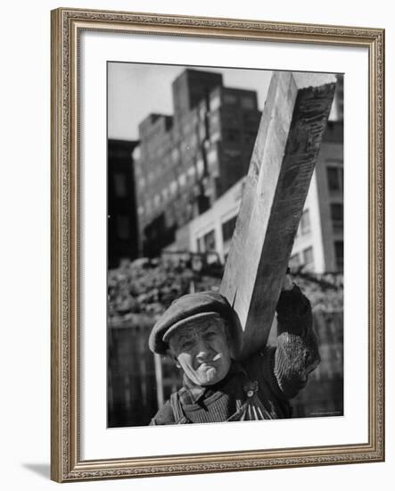 Construction Worker Carrying a Piece of Wood-Cornell Capa-Framed Photographic Print