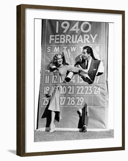 Couple Bursting Through Leap Year Calendar-null-Framed Photo