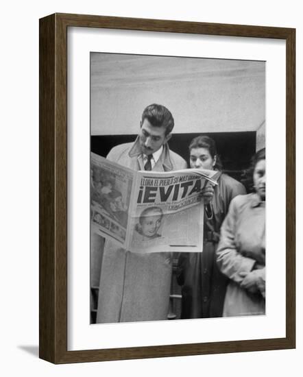 Couple Reading Newspaper Account of the Death of Evita Peron at 33 from Cancer-Alfred Eisenstaedt-Framed Photographic Print