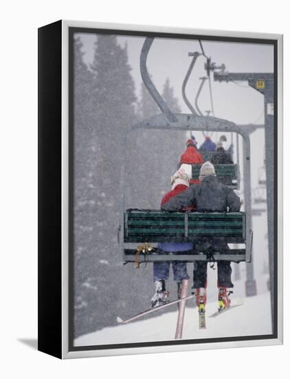 Couple Riding Up the Ski Lift During a Snow Storm, Vail, Colorado, USA-Paul Sutton-Framed Premier Image Canvas