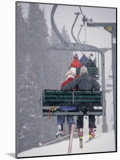 Couple Riding Up the Ski Lift During a Snow Storm, Vail, Colorado, USA-Paul Sutton-Mounted Photographic Print