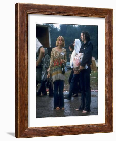 Couple Standing Barefoot on a Road Holding a Bundle and Wine Bottle, Woodstock Music and Art Fair-John Dominis-Framed Photographic Print