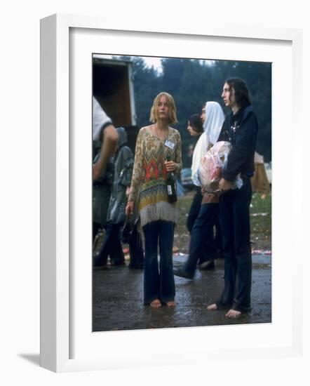 Couple Standing Barefoot on a Road Holding a Bundle and Wine Bottle, Woodstock Music and Art Fair-John Dominis-Framed Photographic Print