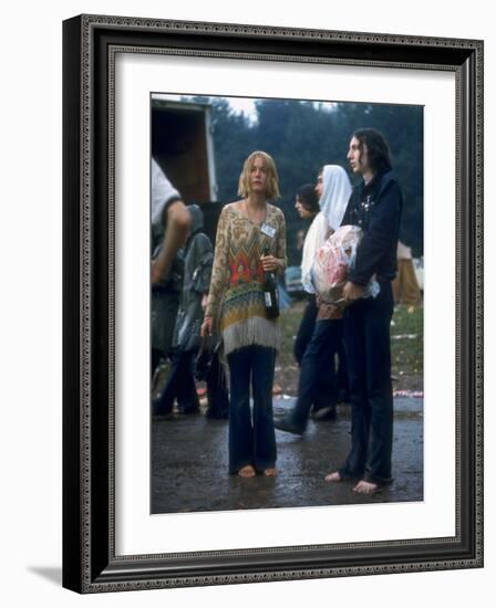 Couple Standing Barefoot on a Road Holding a Bundle and Wine Bottle, Woodstock Music and Art Fair-John Dominis-Framed Photographic Print