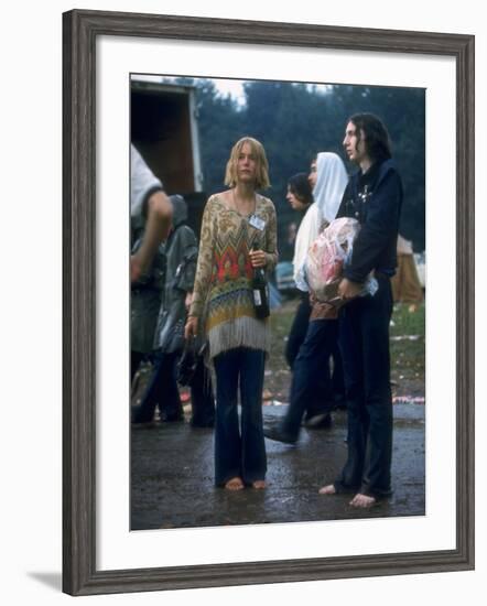 Couple Standing Barefoot on a Road Holding a Bundle and Wine Bottle, Woodstock Music and Art Fair-John Dominis-Framed Photographic Print