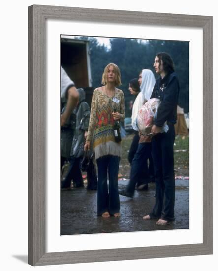 Couple Standing Barefoot on a Road Holding a Bundle and Wine Bottle, Woodstock Music and Art Fair-John Dominis-Framed Photographic Print