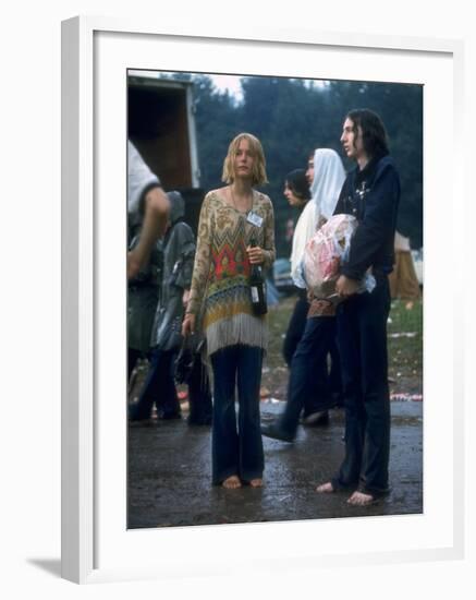 Couple Standing Barefoot on a Road Holding a Bundle and Wine Bottle, Woodstock Music and Art Fair-John Dominis-Framed Photographic Print
