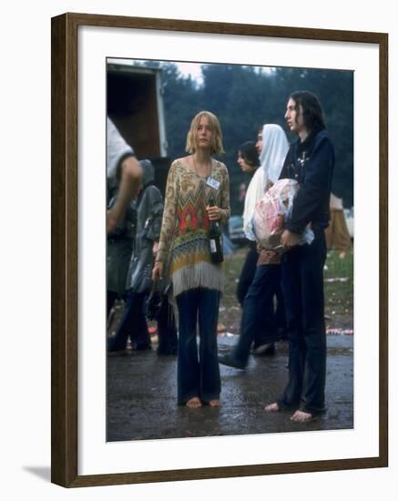 Couple Standing Barefoot on a Road Holding a Bundle and Wine Bottle, Woodstock Music and Art Fair-John Dominis-Framed Photographic Print